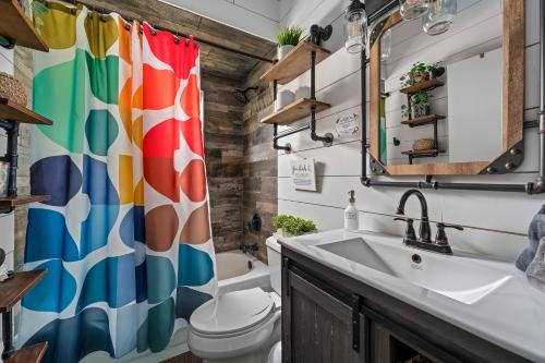 a bathroom with a colorful shower curtain and a sink at Tropical Oasis- Pickleball, Pool, Hot Tub- 15 min to beach in Melbourne