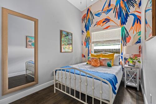 a bedroom with a bed and a mirror at Tropical Oasis- Pickleball, Pool, Hot Tub- 15 min to beach in Melbourne