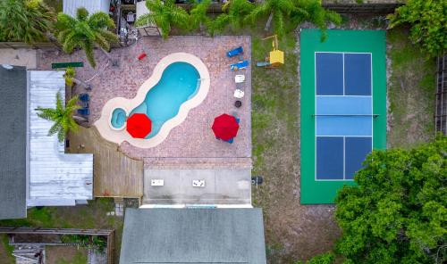 an overhead view of a pool and a tennis court at Tropical Oasis- Pickleball, Pool, Hot Tub- 15 min to beach in Melbourne