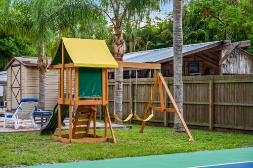 a playground with a play house and a slide at Tropical Oasis- Pickleball, Pool, Hot Tub- 15 min to beach in Melbourne