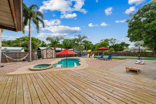 a playground with a pool and a wooden deck at Tropical Oasis- Pickleball, Pool, Hot Tub- 15 min to beach in Melbourne