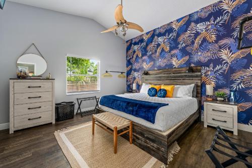 a bedroom with a bed and a blue wall at Tropical Oasis- Pickleball, Pool, Hot Tub- 15 min to beach in Melbourne