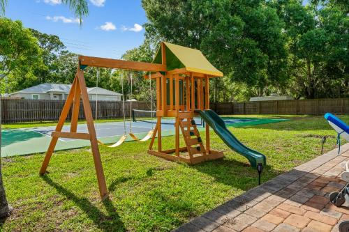 a playground with a slide in a yard at Tropical Oasis- Pickleball, Pool, Hot Tub- 15 min to beach in Melbourne
