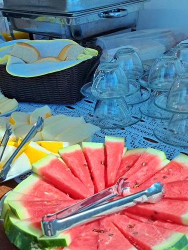 un plato de fruta con pinzas en una mesa en Pousada Porto da Barra Praia, en Porto Seguro