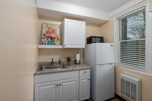 a kitchen with a sink and a refrigerator at Wallys Place in Saugatuck