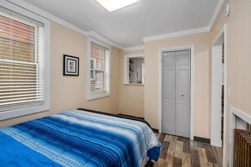 a bedroom with a bed and two windows at Wallys Place in Saugatuck