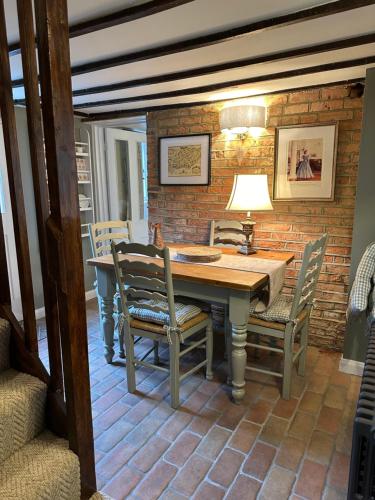 a dining room with a wooden table and chairs at Mantlemas Cottage in Turners Hill