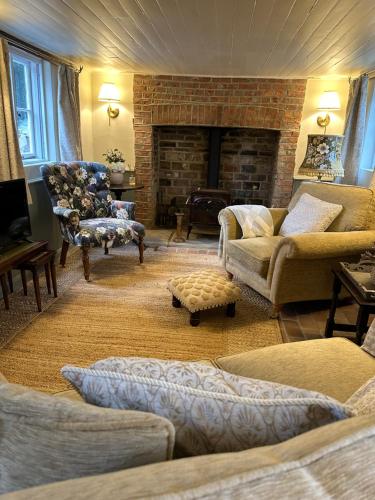 a living room with a couch and a fireplace at Mantlemas Cottage in Turners Hill