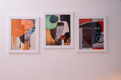 three paintings hanging on a wall at Four Points Suites in Naples