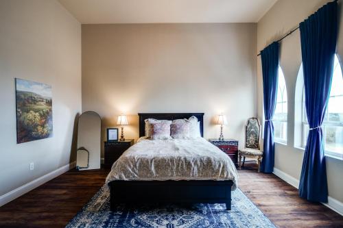 a bedroom with a large bed with blue curtains at The Castle at Rockwall in Rockwall