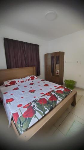 a bedroom with a bed with a flower quilt on it at Apartement Graniet in Paramaribo