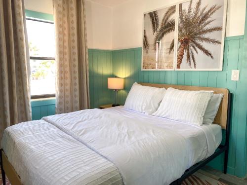 una camera con un letto e un dipinto di palma sul muro di Oasis Palms Resort a St Pete Beach