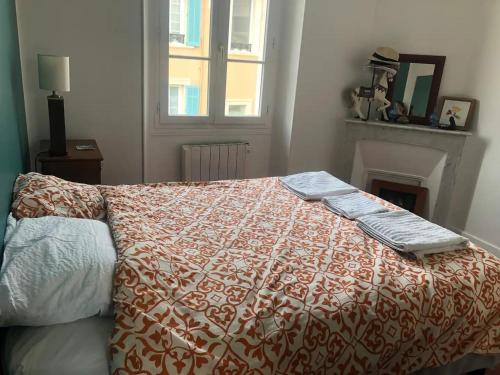 - un lit avec une couette rouge et blanche dans une chambre dans l'établissement Belfort, à Cannes