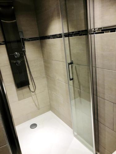 une douche avec une porte vitrée dans une salle de bain dans l'établissement Appartement climatisé dans un quartier très calme, à Six-Fours-les-Plages