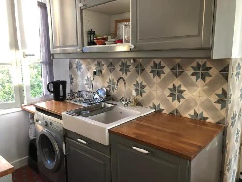 une cuisine avec un évier et une machine à laver dans l'établissement Belfort, à Cannes