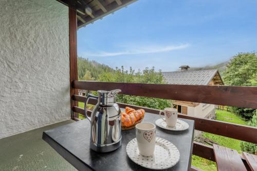 - une table avec une cafetière et des tasses sur le balcon dans l'établissement Rafforts E8 - Happy Rentals, à Chamonix-Mont-Blanc