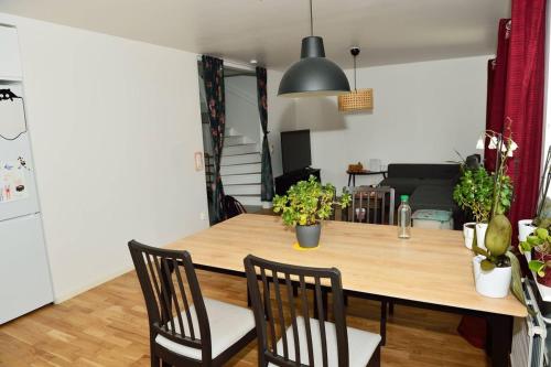 a kitchen and dining room with a wooden table and chairs at Townhouse in a convenient location in Täby