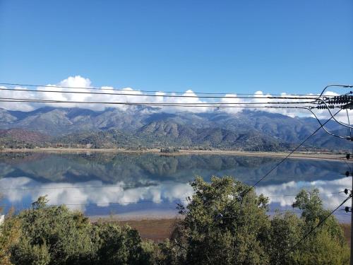 a view of a lake with mountains in the background at Acogedora Cabaña Entorno Natural in El Monte