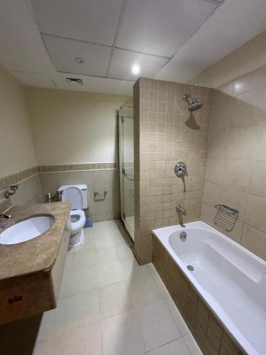 a bathroom with a tub and a sink and a toilet at Beach view in King Abdullah Economic City
