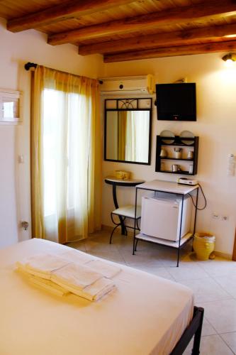 a bedroom with a bed and a table and a tv at Alisachni in Serifos Chora