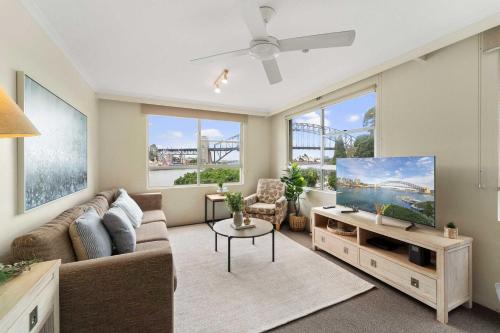 a living room with a couch and a tv at Harbourside 10 in Sydney