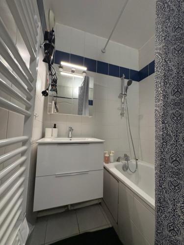 a white bathroom with a sink and a bath tub at F3 avec Projecteur à 2 min du métro in Saint-Ouen