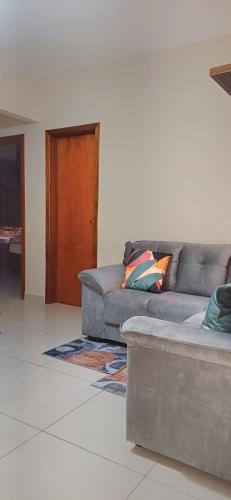 a living room with a gray couch and a door at Apartamento Capitólio D'Loren dos lagos 4º andar in Capitólio