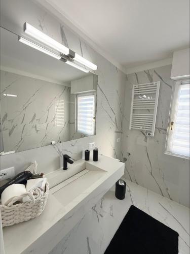 a white bathroom with a sink and a mirror at Catullo Loft Near Verona in Dossobuono