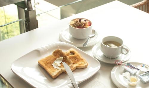 a table with two plates of toast and a cup of coffee at Hotel Las Cascadas in San Pedro Sula