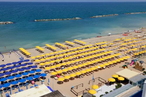 an overhead view of a beach with yellow and blue umbrellas at Nautilus Family Hotel in Pesaro