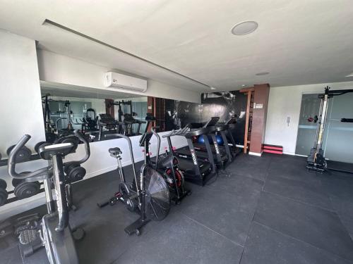 a gym with bikes and tread machines in a room at Apto moderno COP30 com Área de Lazer e Estacionamento in Belém