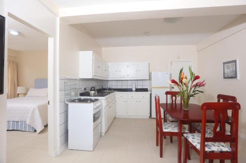 a kitchen and dining room with a table and a bed at Brise De Mer - Villa with captivating views of the Caribbean Sea villa in Cap Estate