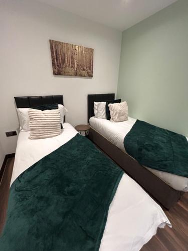 two beds sitting next to each other in a room at Betto Lavish Apartment Sleeps 4 Central Hull HU1 Central in Hull