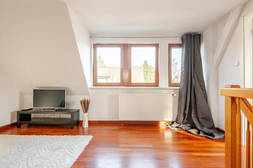 a living room with a television and a window at Familien Oase mit Jacuzzi und Garten in Hamburg