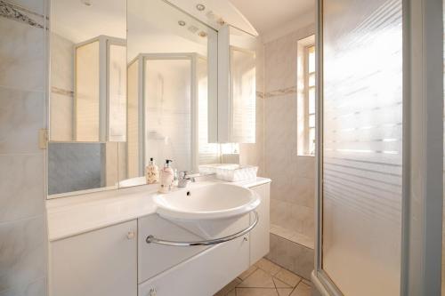 a white bathroom with a sink and a shower at Familien Oase mit Jacuzzi und Garten in Hamburg