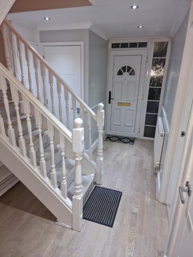 a white staircase with a white door in a house at NightRest Homes Smart TV In Each Room - Parking - Hemel Hempstead in Hemel Hempstead