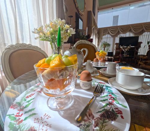 a table with a glass bowl of fruit on a table at Residencial Belle Maison in Cusco