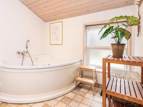 a bathroom with a tub and a potted plant at Tranquil Haven in Lyngsa - By Traum Ferienwohnungen in Sæby