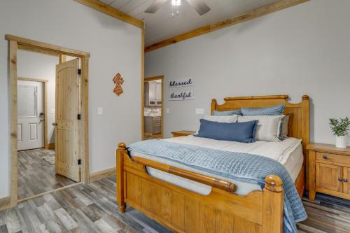 a bedroom with a wooden bed with blue pillows at Greers Ferry Lake Access and Deck Group Getaway! in Heber Springs