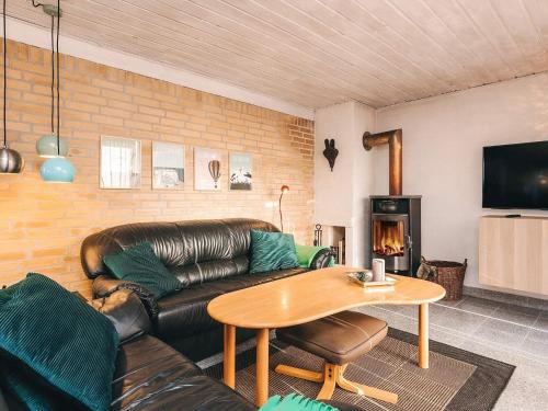 a living room with a leather couch and a table at 4 star holiday home in Hals in Hals