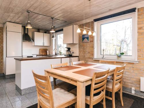 a kitchen and dining room with a wooden table and chairs at 4 star holiday home in Hals in Hals