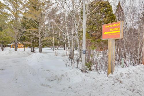 a sign in the snow next to a street at 2 Ponds and Trail Access Peaceful Cabin in Calumet! in Calumet