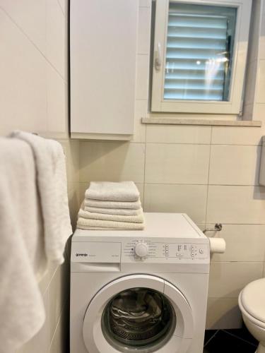 a white washer and dryer in a bathroom at Apartments Versus in Mlini