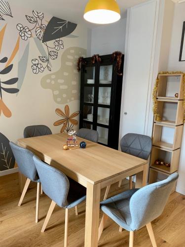 une salle à manger avec une table et des chaises en bois dans l'établissement Place Des Vosges, à Gérardmer