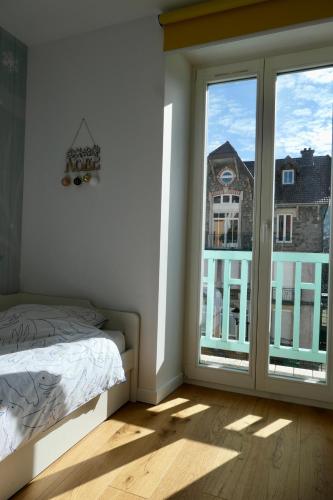 une chambre avec un lit et une grande fenêtre dans l'établissement Place Des Vosges, à Gérardmer