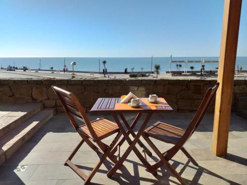 a table with two chairs and the ocean in the background at Hotel Amsterdam in Mar del Plata