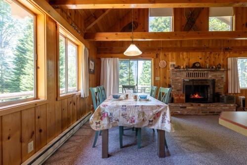 comedor con mesa y chimenea en Cub Garden, en Island Park