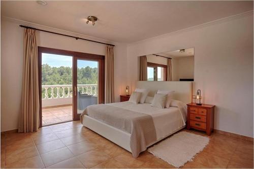 サン・ラファエル・デ・サ・クレウにあるVilla with charm and privacyの大きなベッドと大きな窓のある寝室