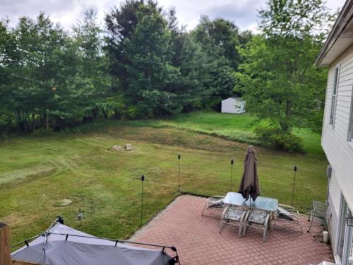a patio with two chairs and an umbrella and a yard at Cozy House in Long Pond 3 bedrooms 10 people in Long Pond