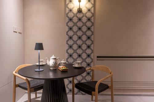 a table with two chairs and a table with a lamp at Locanda Expanificio in Agrigento